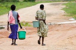 meninas com baldes buscam água na áfrica